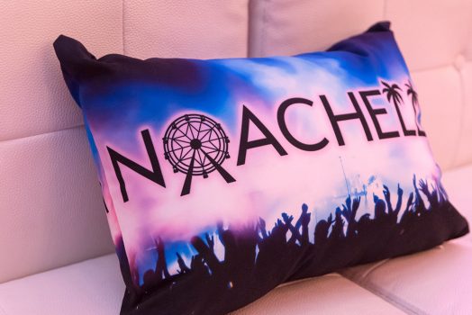 Custom rectangular pillow with Noachella logo printed on photo of a concert stage; mostly blue and black tones.